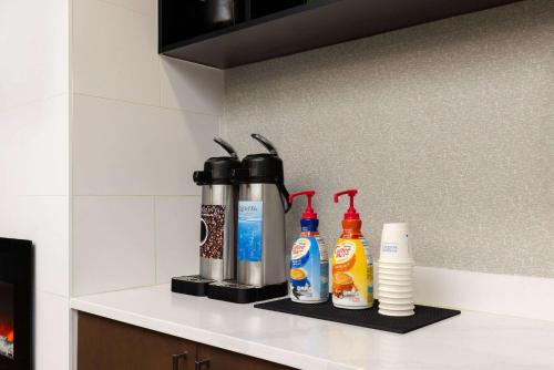 a shelf with bottles of condiments on a kitchen counter at La Quinta by Wyndham Santa Clarita - Valencia in Stevenson Ranch
