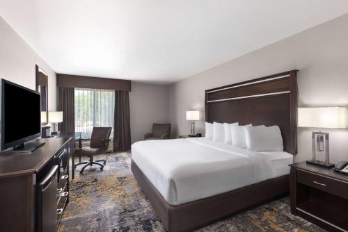 a hotel room with a large bed and a flat screen tv at La Quinta by Wyndham Sioux Falls in Sioux Falls