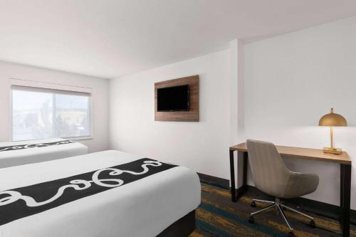 a hotel room with a bed and a desk and a chair at La Quinta by Wyndham Kennewick in Kennewick