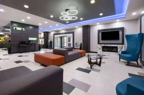a living room with a couch and a tv at La Quinta by Wyndham Muskogee in Muskogee