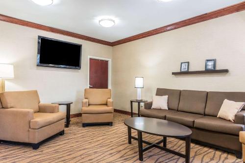 a living room with a couch and chairs and a flat screen tv at Sleep Inn & Suites University-Shands in Gainesville