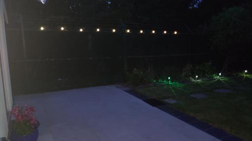 a patio at night with lights on a fence at Chiltern Nursuries in Amersham