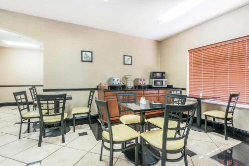 a dining room with a table and chairs and a kitchen at Sleep Inn & Suites University-Shands in Gainesville