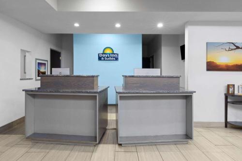 a lobby of a hotel with two counters at Days Inn & Suites by Wyndham Lubbock Medical Center in Lubbock