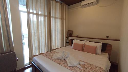 a bedroom with a bed with a bow on it at City Nest Inn in Kandy