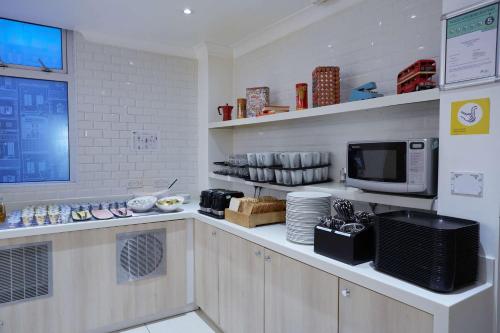 a kitchen with a counter with a microwave at Comfort Inn Victoria in London