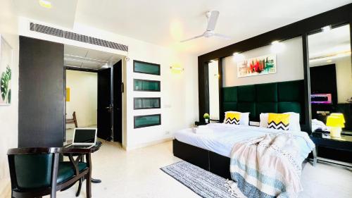a bedroom with a bed and a laptop on a chair at BluO Studio - M Block Mkt Greater Kailash in New Delhi