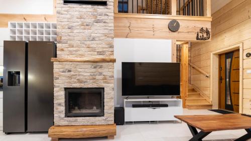 a living room with a tv and a fireplace at Bieszczadzki Biedak in Polańczyk