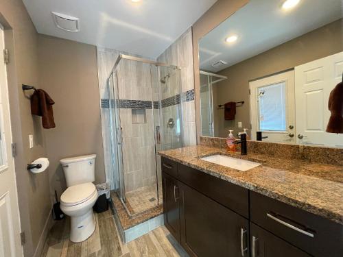 a bathroom with a shower and a toilet and a sink at Forever Sunshine - Beach Vacation Rental in Clearwater Beach