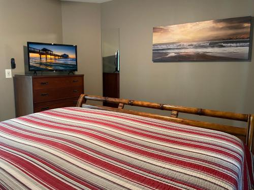 a bedroom with a bed and a flat screen tv at Forever Sunshine - Beach Vacation Rental in Clearwater Beach