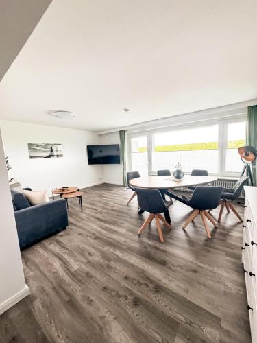 a living room with a couch and a table at Seaside Döse Appartement - Free Parking & WiFi in Cuxhaven
