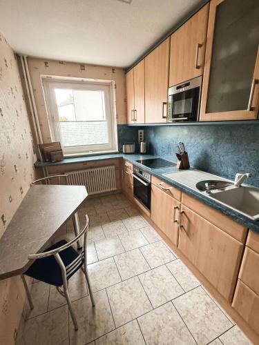 a kitchen with a counter and a sink and a table at Seaside Döse Appartement - Free Parking & WiFi in Cuxhaven
