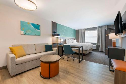 a hotel room with a couch and a bed at Comfort Suites St Augustine Historic District Area in Saint Augustine
