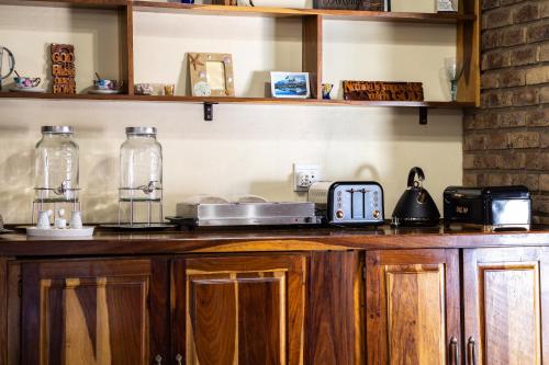 a kitchen with wooden cabinets and a counter top at Thatch Haven Guesthouse in Centurion