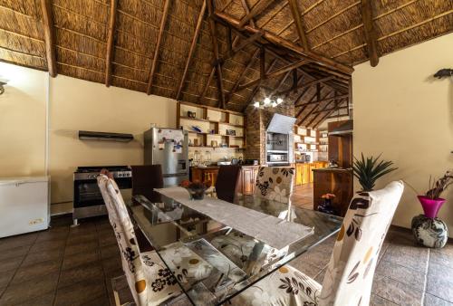 a kitchen with a table and chairs in a room at Thatch Haven Guesthouse in Centurion