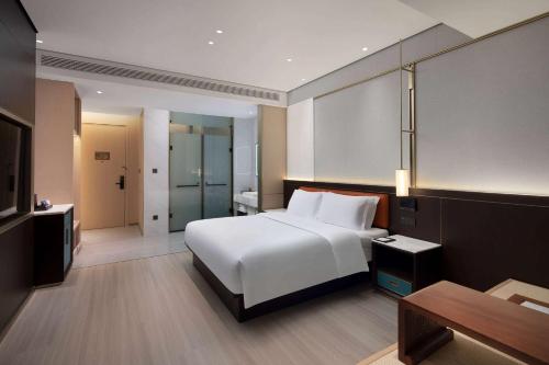 a bedroom with a large white bed and a table at Days Hotel by Wyndham Changsha Kaifu in Changsha