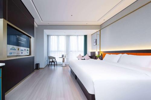 a large white bed in a hotel room at Days Hotel by Wyndham Changsha Kaifu in Changsha