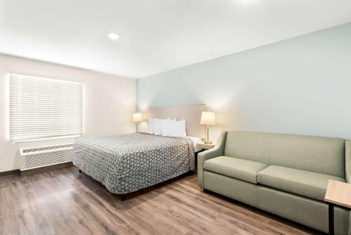 a bedroom with a bed and a couch at WoodSpring Suites Savannah West Chatham Parkway in Savannah