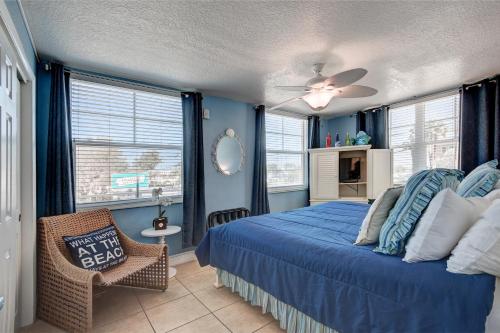 een slaapkamer met een bed, een stoel en ramen bij Clearwater Beach Suites #201 in Clearwater Beach