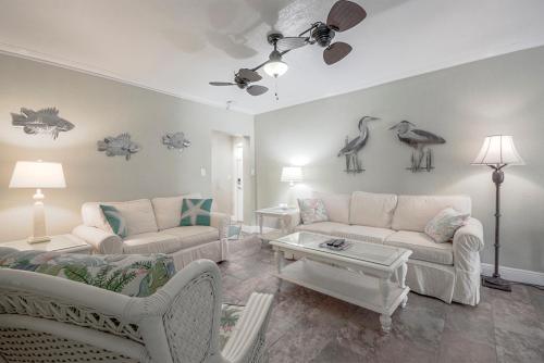 a living room with two couches and birds on the wall at Clearwater Beach Suites #105 in Clearwater Beach