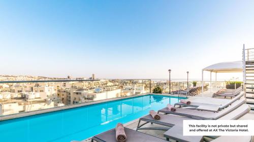 AX Palazzo Capua في سليمة: مسبح مزود بكراسي استرخاء وإطلالة على المدينة