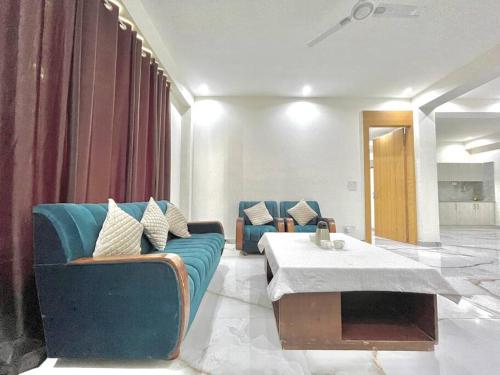 a living room with a blue couch and a table at host jatin kasauli crest 7o1827o7o3 in Kasauli