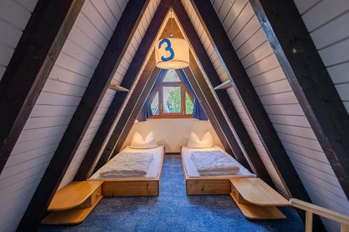 two beds in a room with a window at Ferienwohnpark Immenstaad am Bodensee Nurdachhaus Typ 7 ND 39 in Immenstaad am Bodensee