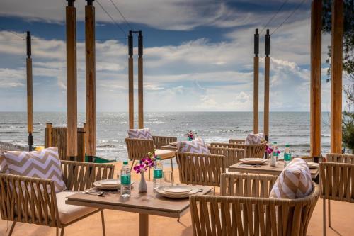 een restaurant met tafels en stoelen op het strand bij Sibaya Beach Resort, Morjim in Morjim