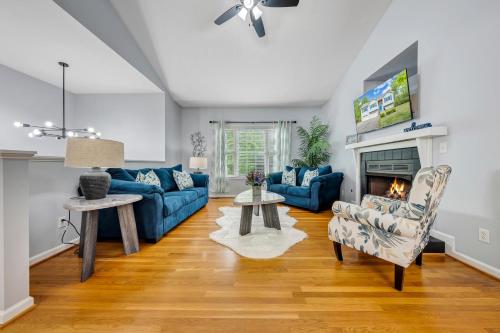 a living room with blue couches and a fireplace at Modern Lake Acess Retreat, Hot Tub, Pet Friendly! in Huddleston
