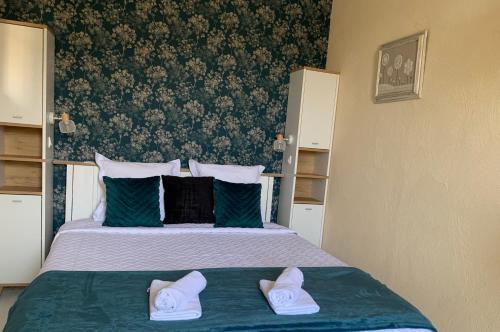 - une chambre avec un lit et 2 chaussons blancs dans l'établissement La Maison du Bourg proche St Emilion, à Puisseguin