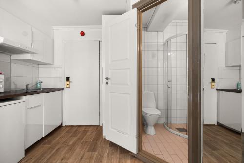 a bathroom with a toilet and a glass door at BUDGETEL- Kong Oscarsgate 44 in Bergen