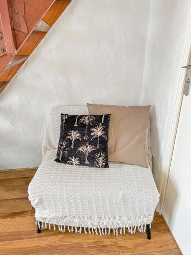 a white couch with a pillow in a room at Calme Jardin & Parking prox Royan Appart 2 in Médis