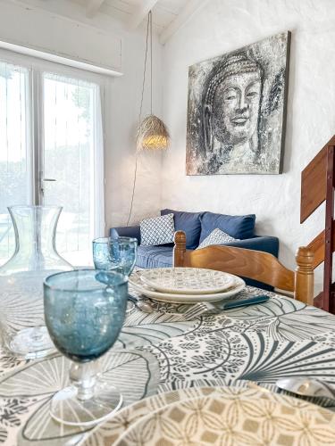 a dining room table with plates and glasses on it at Calme Jardin & Parking prox Royan Appart 2 in Médis