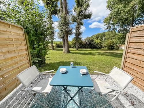 a patio with a blue table and two chairs at Calme Jardin & Parking prox Royan Appart 2 in Médis