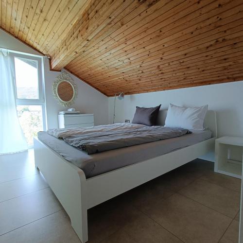 a bedroom with a bed with a wooden ceiling at Villa Regina Serafina in Balchik