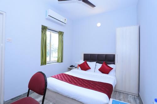 a bedroom with a large bed with red pillows at Super Townhouse Prince Palace in Trivandrum