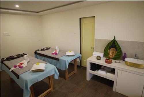 a bathroom with two beds and a sink and a mirror at Greenleaf The Resort & Spa, Ganpatipule in Ganpatipule