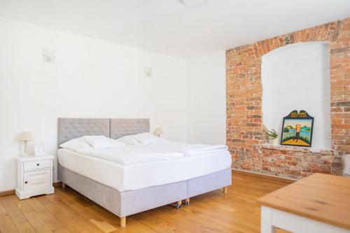 a bed in a room with a brick wall at Oficyna Krobielowice in Kąty Wrocławskie
