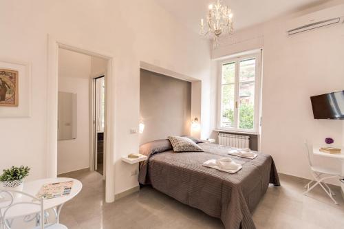 ローマにあるRelais La Torrettaの白いベッドルーム(ベッド1台、テーブル、椅子付)