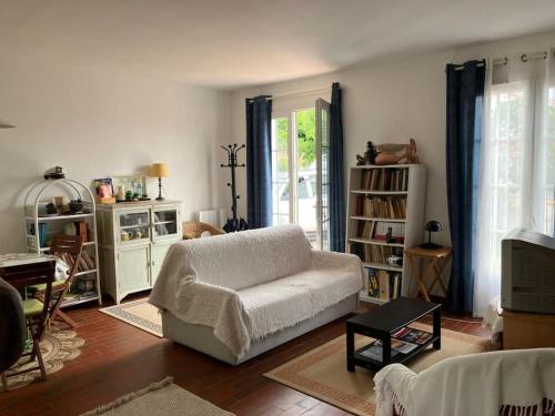 un salon avec un canapé blanc et une télévision dans l'établissement Maison à Vaux-sur-Mer, à Vaux-sur-Mer
