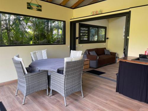 a bedroom with a table and chairs and a couch at Villa ManaOra in Taravao
