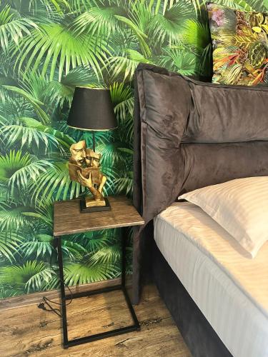 a lamp on a table next to a bed at Complex Omnia - Apartamente Husi in Huşi