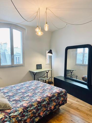 une chambre avec un lit, un miroir et une table dans l'établissement 3 pièces lumineux paris Montmartre, à Paris