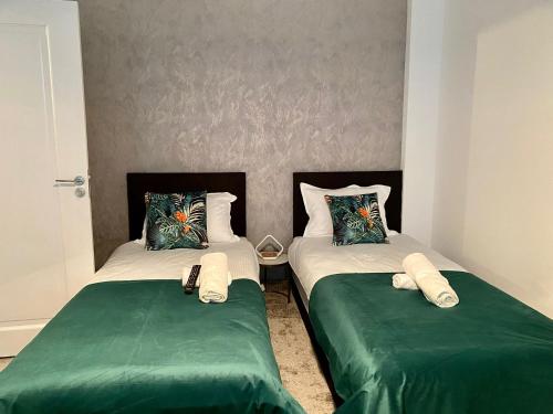 two beds sitting next to each other in a bedroom at Complex Omnia - Apartamente Husi in Huşi
