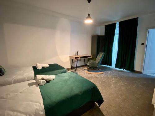 a hotel room with two beds and a desk at Complex Omnia - Apartamente Husi in Huşi
