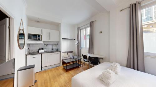 - une cuisine avec des placards blancs et une table avec des serviettes dans l'établissement Bluestay 235 - Superbe appartement à Paris, à Paris