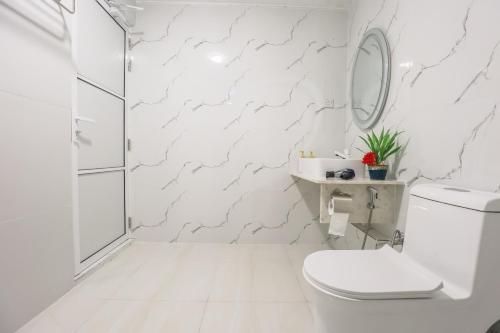 a white bathroom with a toilet and a shower at Thoddoo Island Holiday in Thoddoo