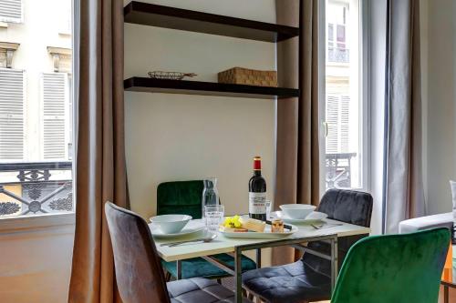 - une table à manger avec une bouteille de vin et des chaises dans l'établissement Bluestay 236 - Superbe appartement à Paris, à Paris