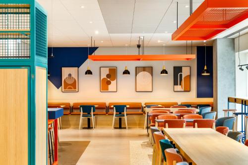 a dining room with tables and chairs at ibis budget Manchester Airport T2 in Hale