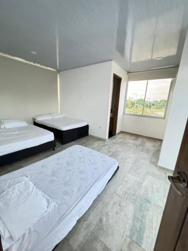 a bedroom with two beds and a large window at Casa quinta Aluna in Carmen de Apicalá